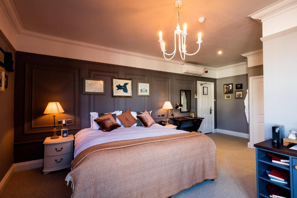 伦敦酿酒者旅馆的一间卧室配有一张大床和一个吊灯。