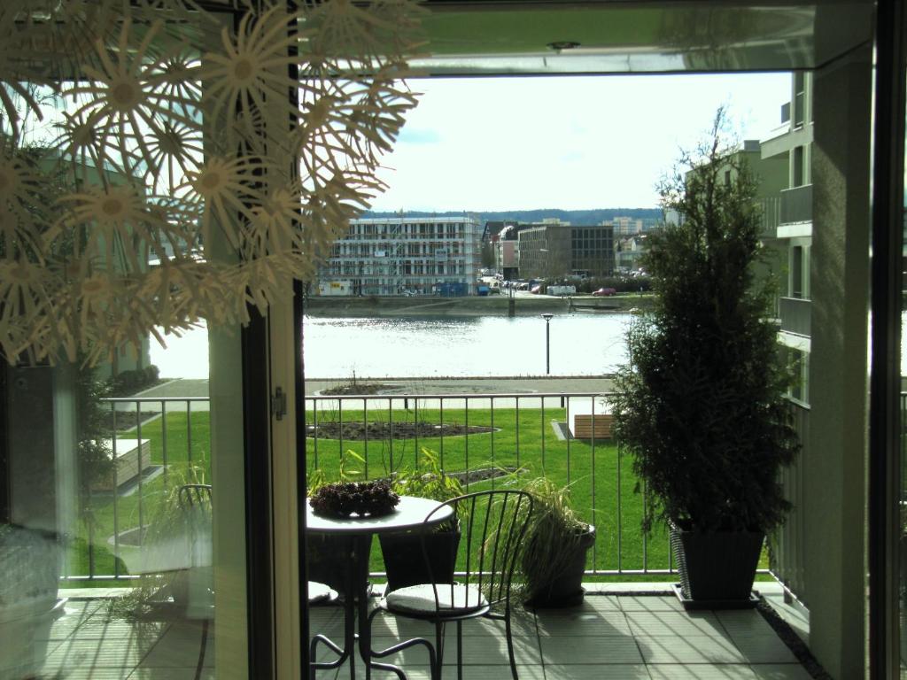 康斯坦茨Ferienwohnung Lac Konstanz的阳台配有桌椅,享有水景。