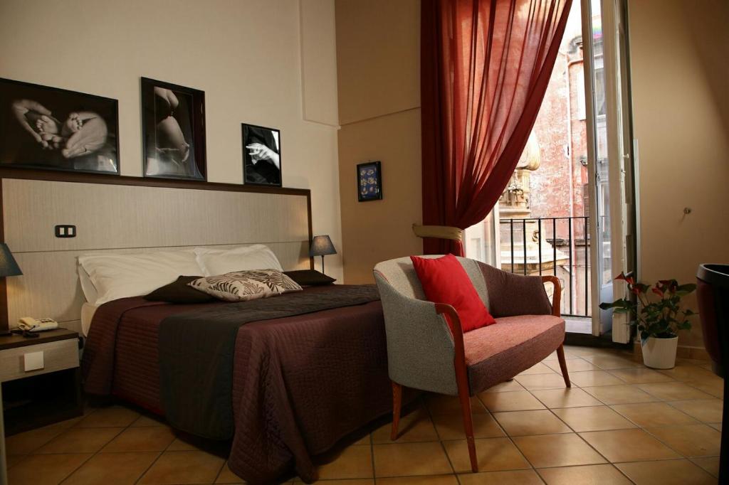 那不勒斯卡拉瓦乔酒店的卧室配有床、椅子和窗户。