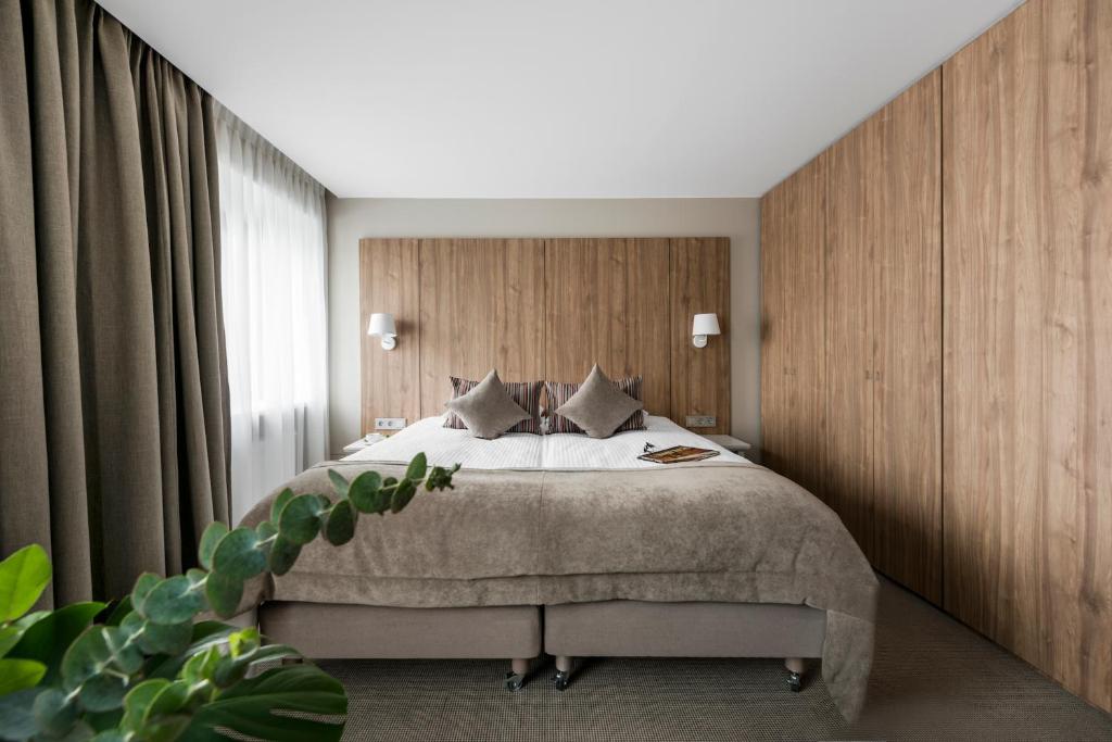 乌克梅尔盖比格斯通酒店的一间卧室配有一张带木墙的大床