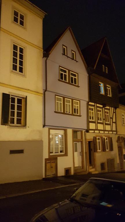 阿沙芬堡Miniapartment am Dalberg的白色的建筑,晚上在街上有窗户