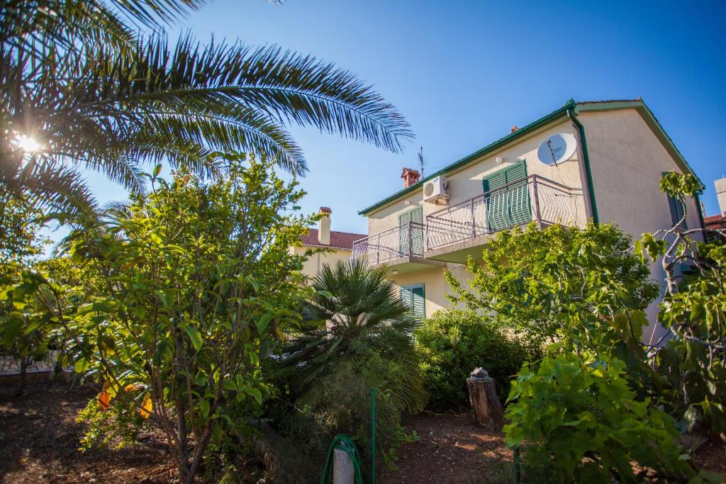 茨雷斯Villa Vosilla Apartments的带阳台和棕榈树的房子