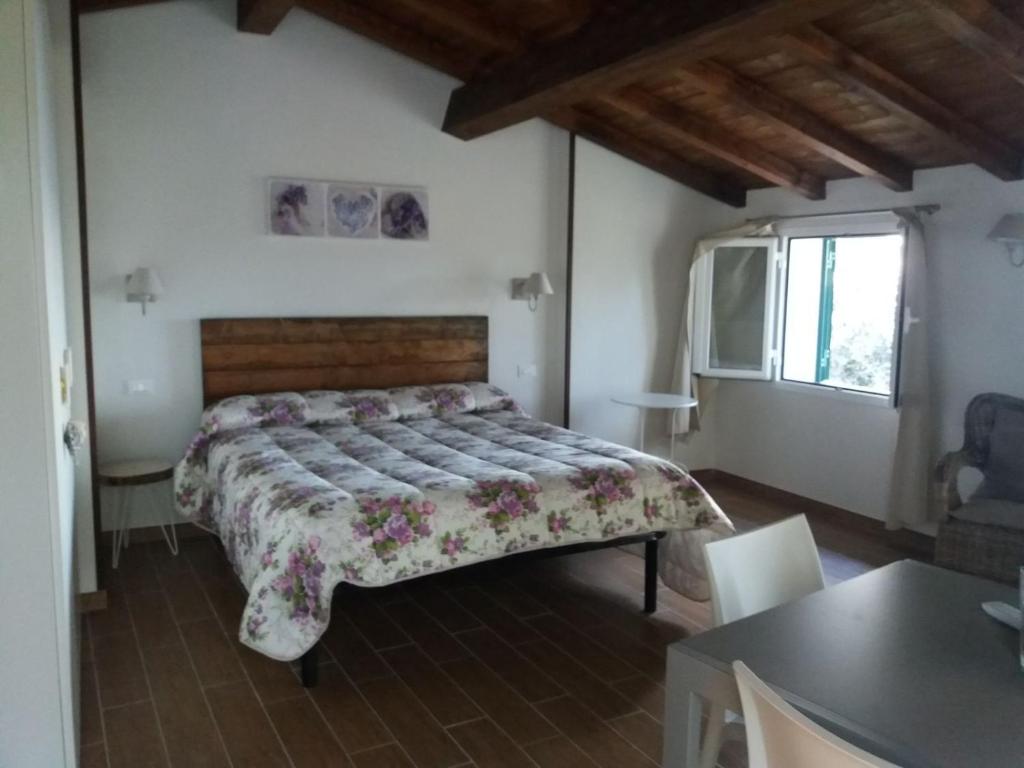 因佩里亚La Torretta的卧室配有一张床铺,位于带桌子的房间