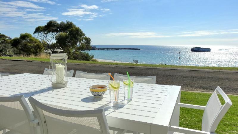 潘尼萧米尔邦德度假屋的一张白色桌子,旁边是大海,上面有饮料