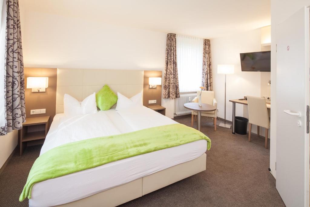 弗莱堡弗赖堡城市酒店的酒店客房设有一张大床和一张书桌。