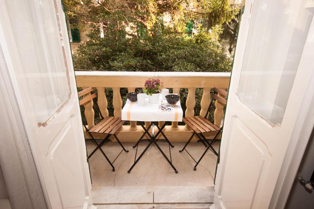 热那亚Perdiana House的阳台的开放式门,配有桌椅