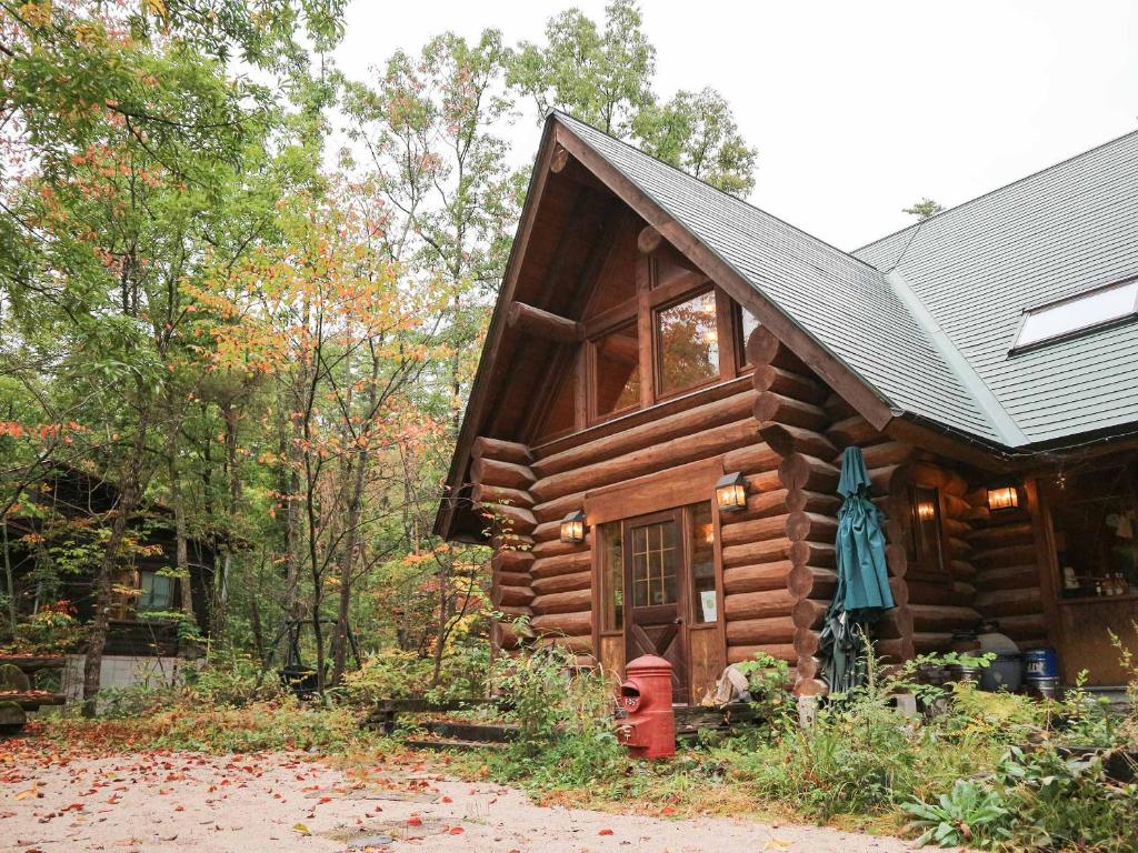 安昙野市Canadian Loghouse Inn AzuminoYujin的小木屋前面有红色消防龙头