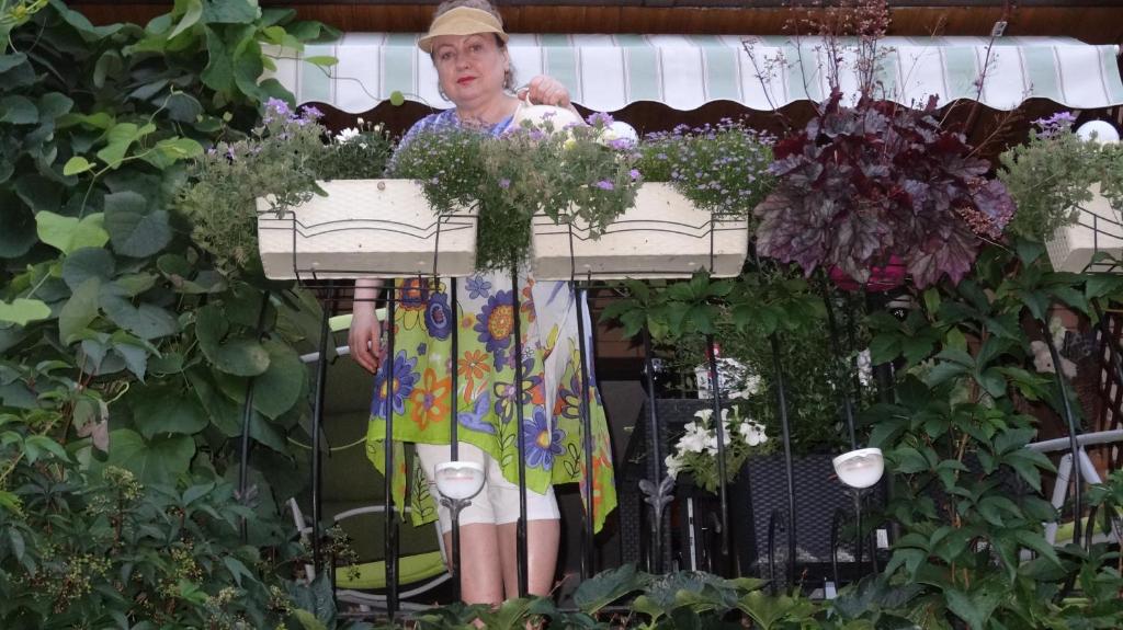 米兹多洛杰普德克克尔纳吉姆酒店的站在鲜花盛开的花园中的女人