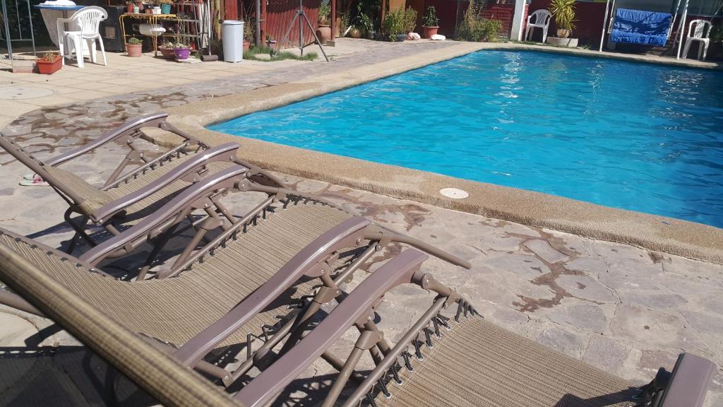 PutaendoCasa Blanca Rinconada de Silva的游泳池旁设有两把草坪椅