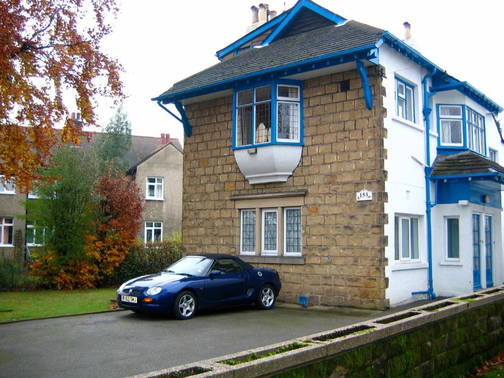 利兹The Tops Self Catering的停在房子前面的蓝色汽车