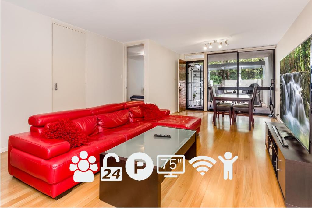 珀斯城市花园公寓的客厅配有红色沙发和电视