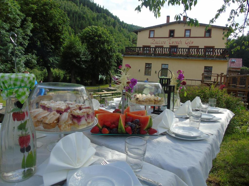 耶德利纳-兹德鲁伊Zacisze Trzech Gór的一张桌子,上面有白色的桌布,上面有食物