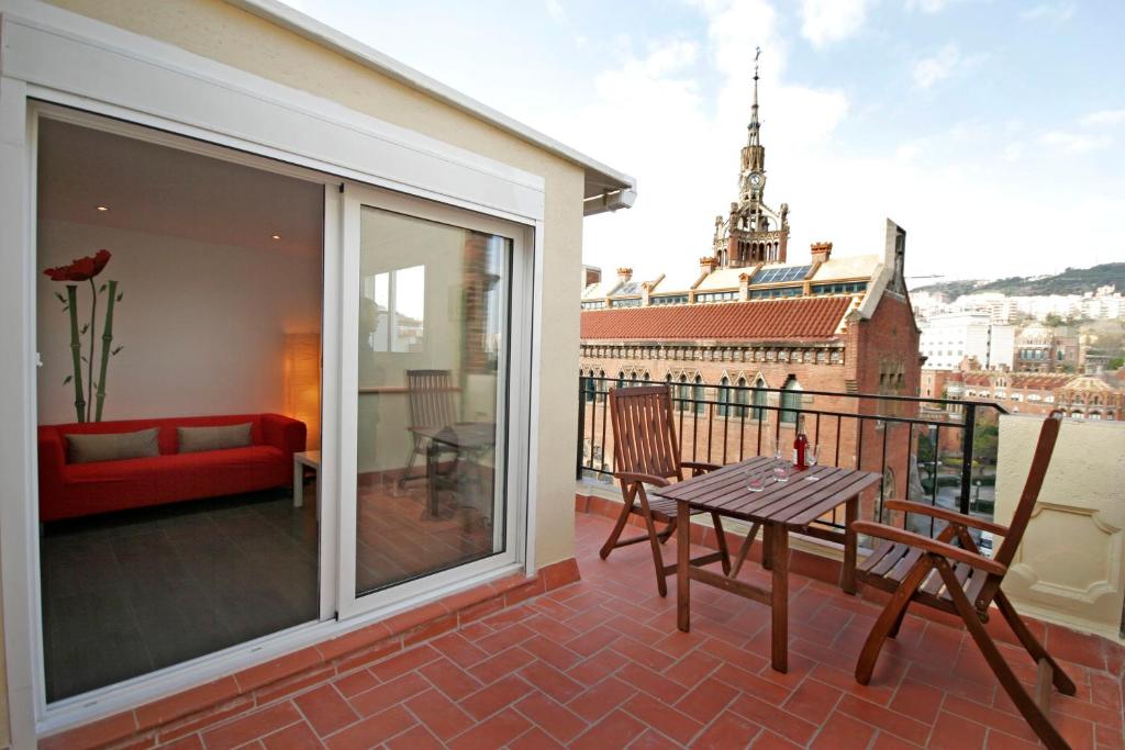 巴塞罗那Sant Pau Terraces Apartments的阳台的天井配有桌椅