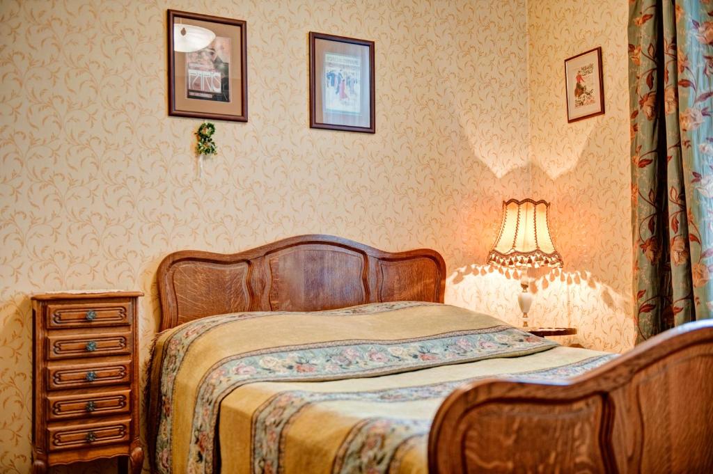 波兹南复古公寓酒店的一间卧室配有一张床和一张带台灯的桌子