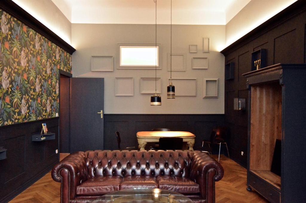 柏林Linnen Luxx Apartment的一张皮沙发,位于带桌子的房间