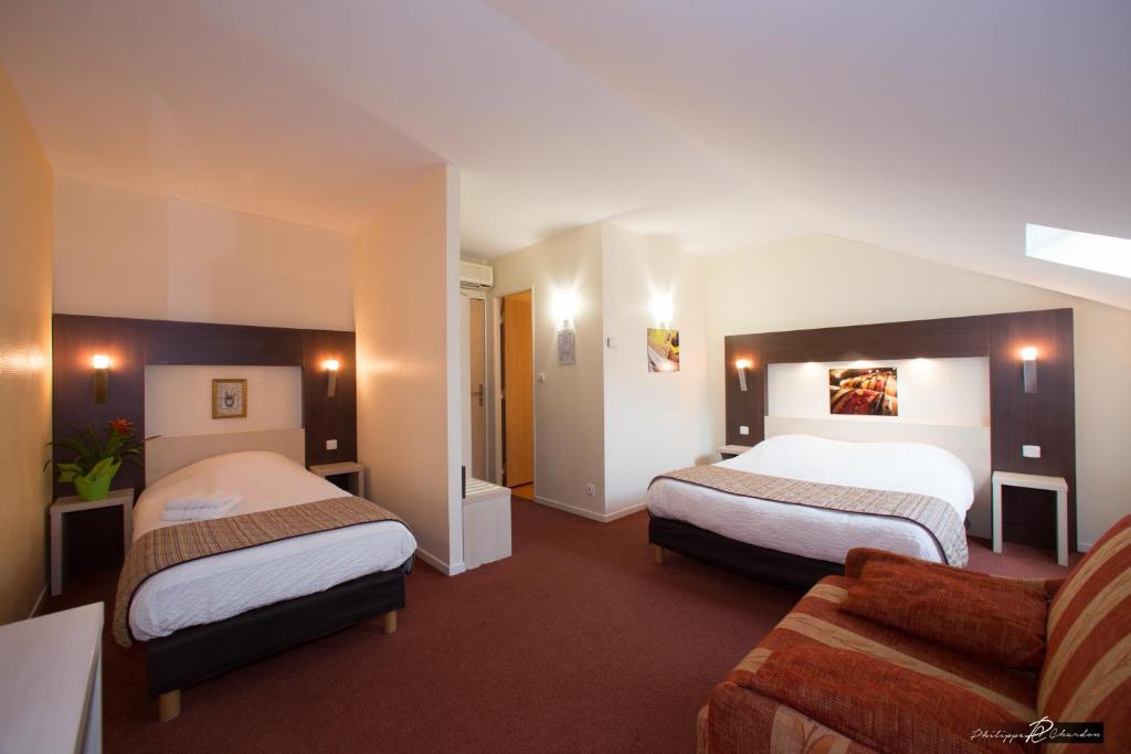 圣吉尔密斯Logis Jum'Hotel的酒店客房,设有两张床和一张沙发