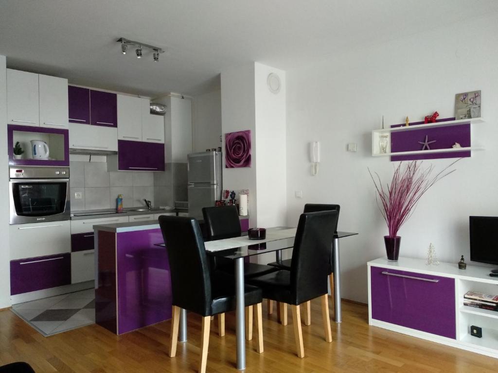 瓦拉日丁A romantic getaway in Varaždin的厨房配有紫色橱柜和桌椅