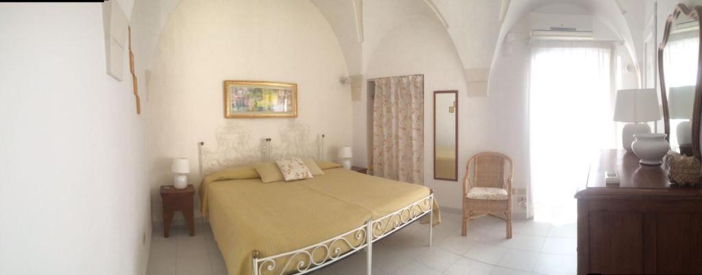 马丁纳弗兰卡卡赛斯帕梭尼历史中心乡村酒店的一间白色客房内的床铺卧室