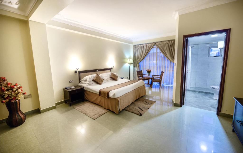 坎帕拉Hotel Sojovalo的卧室配有床、桌子和门