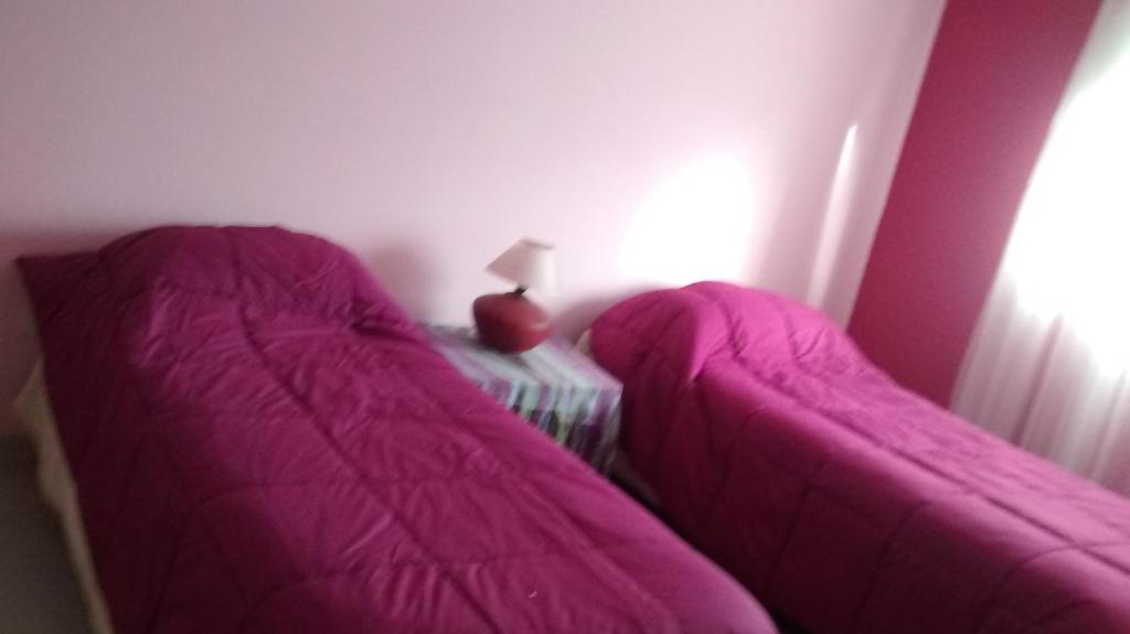 坦迪尔Departamentos R y R Azcuénaga的一张带粉红色床单的床,位于客房内