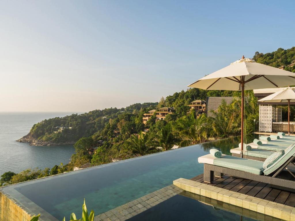 卡马拉海滩Villa Samira by Elite Havens的一个带椅子和遮阳伞的游泳池以及大海