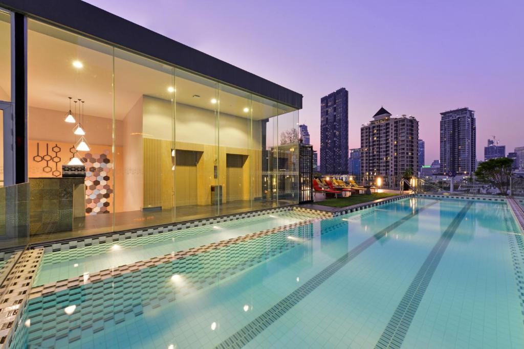 曼谷曼谷德特尔酒店的一座城市天际线建筑屋顶上的游泳池