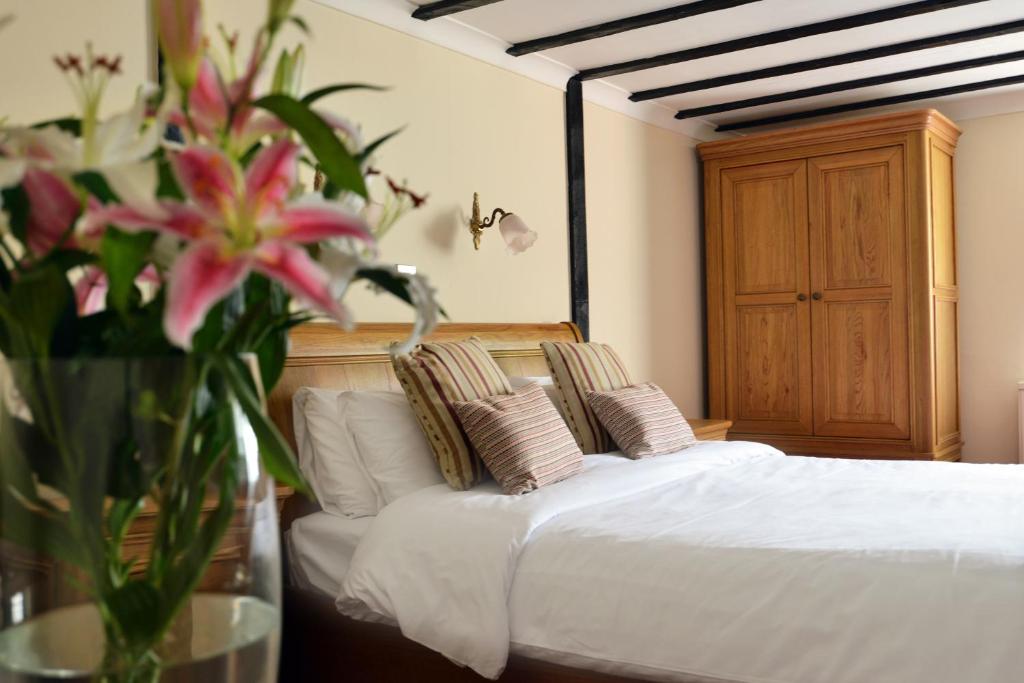 塞得利斯坎贝砖墙酒店的一间卧室,配有一张带花瓶的床