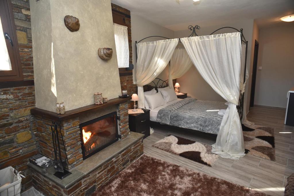 卡托劳塔翁Guesthouse Athanasiou的一间卧室配有一张床和一个壁炉