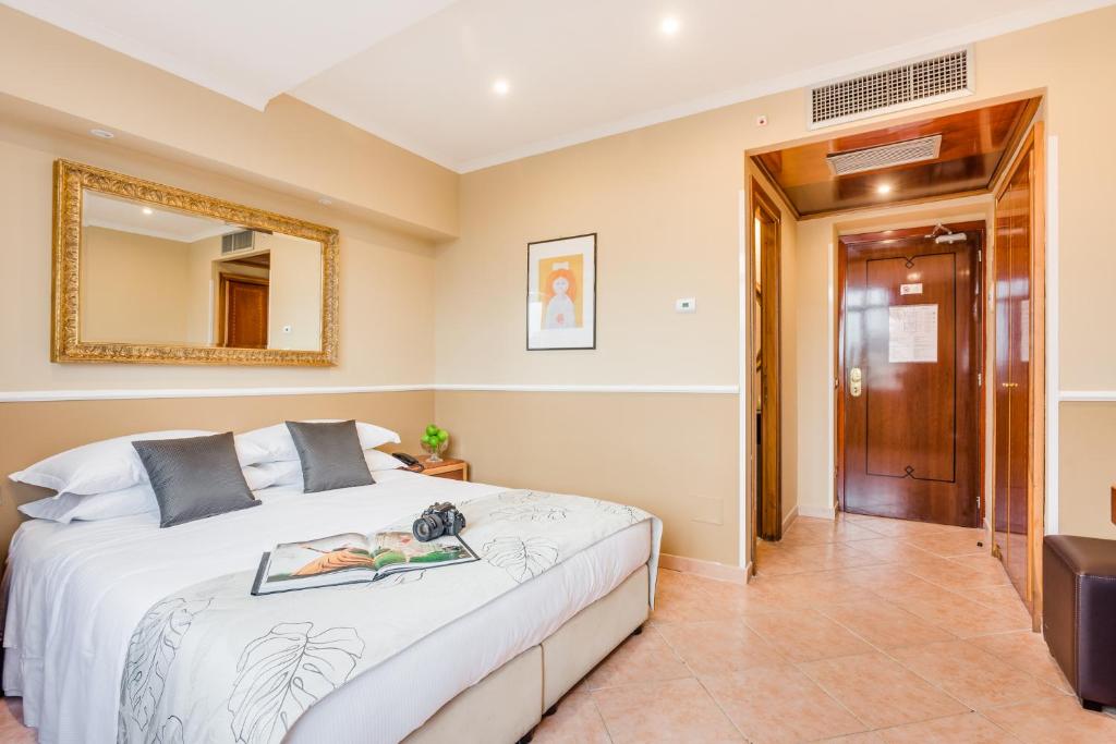 罗马阿基米德莱里酒店的一间卧室配有一张床和镜子