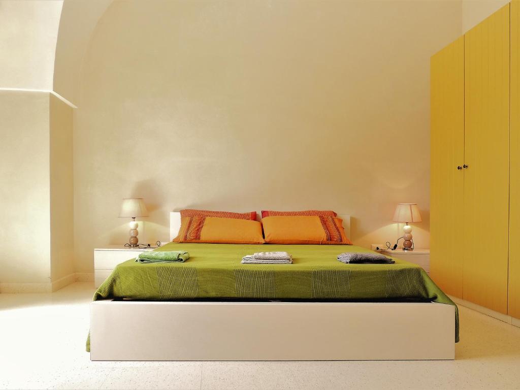 迪索Oikia Vacanze Diso Giulia的一间卧室配有带橙色和绿色床单的床
