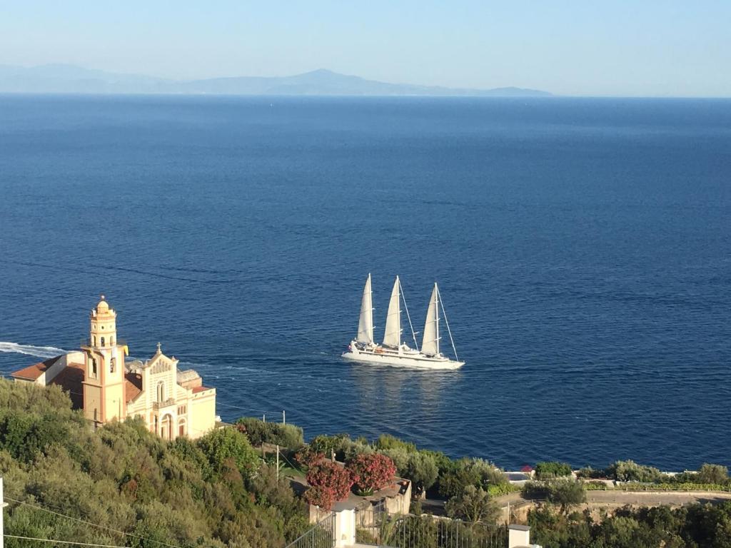 康加德马里尼Blue Dream - Amalfi Coast的城堡附近的水中一艘有两艘帆船的船