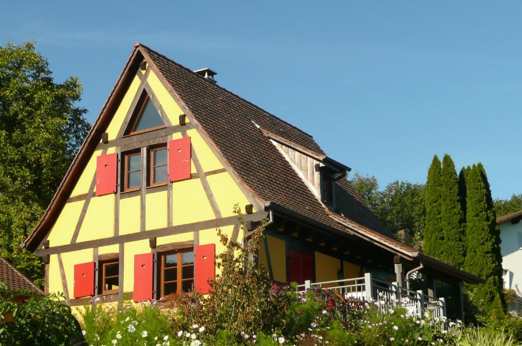 Raedersdorf拉波姆德品度假屋的一座红色和黄色的房屋