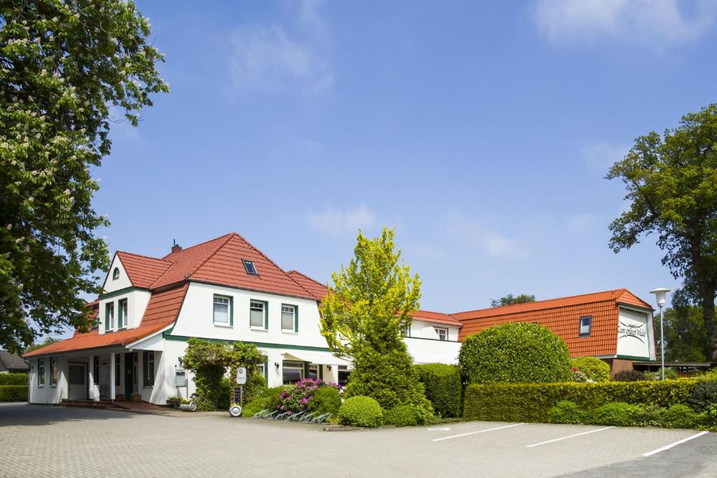 诺尔德霍尔茨Landgasthof "Zum grünen Walde"的白色房子,有红色屋顶