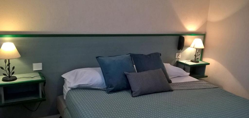 Bas-Mauco埃里奥斯餐厅酒店的一间卧室配有一张带蓝色枕头的床和两盏灯。
