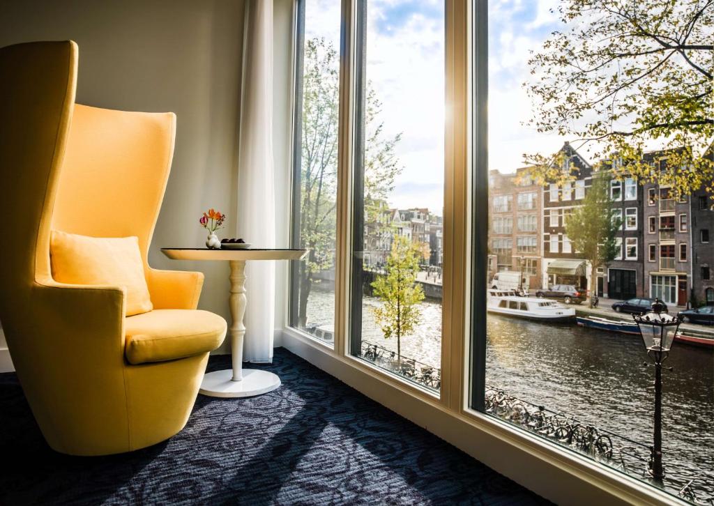 阿姆斯特丹阿姆斯特丹安达仕王子运河凯悦概念酒店的坐在大窗户前的黄色椅子