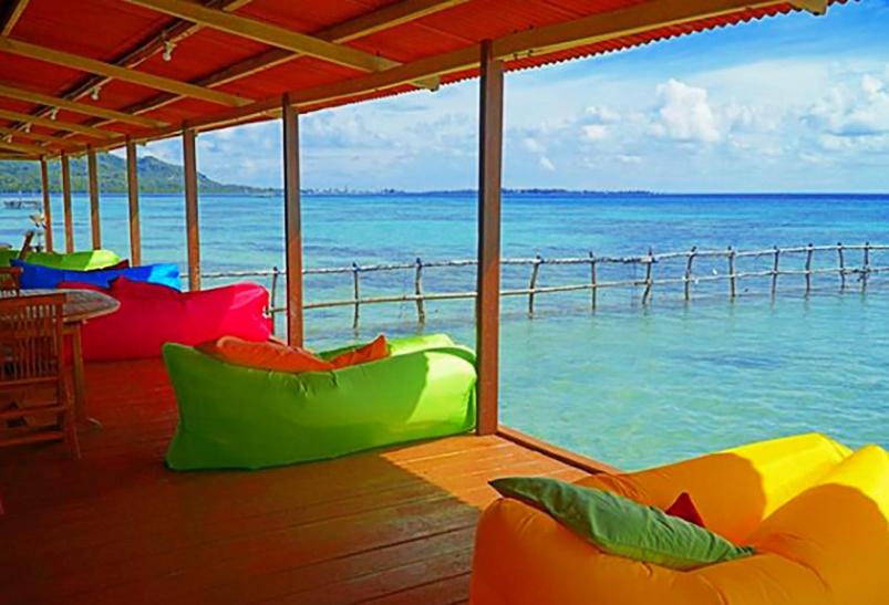 卡里蒙贾瓦阿斯利卡里姆尼亚瓦新小屋酒店的门廊享有海景,配有色彩缤纷的枕头