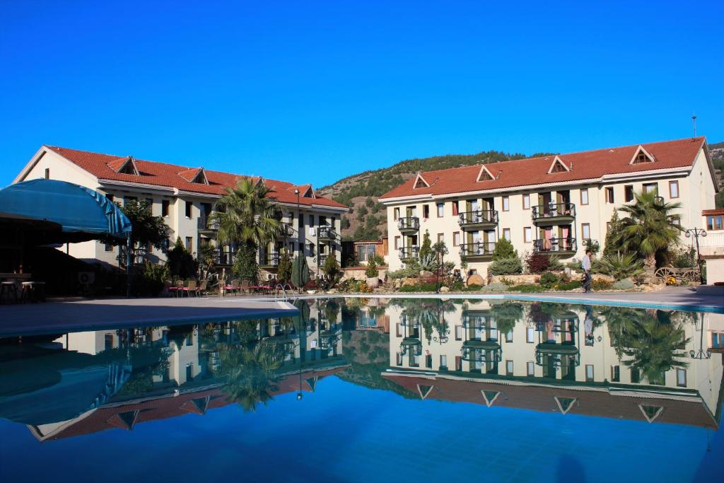 帕莫卡莱Halıcı Hotel Resort & SPA的前面有一个水池的酒店