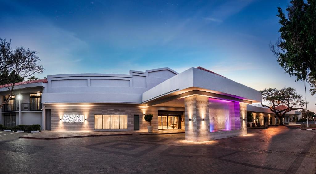 哈博罗内Avani Gaborone Resort & Casino的停车场内紫色灯的大建筑