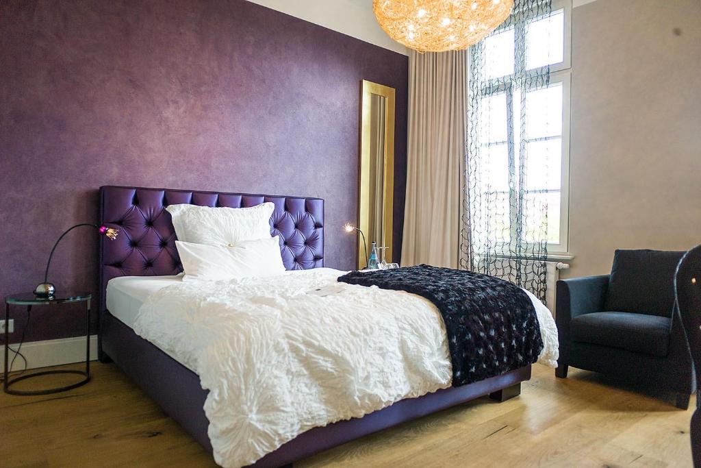 奥尔登堡罗斯博姆设计酒店的紫色卧室配有一张床和一把椅子
