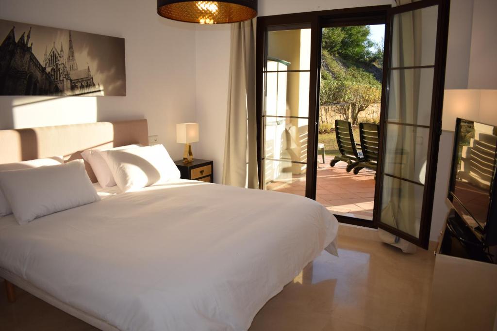 贝纳阿维斯Jardin Vista Las Jacarandas的卧室设有一张白色大床和一个庭院。