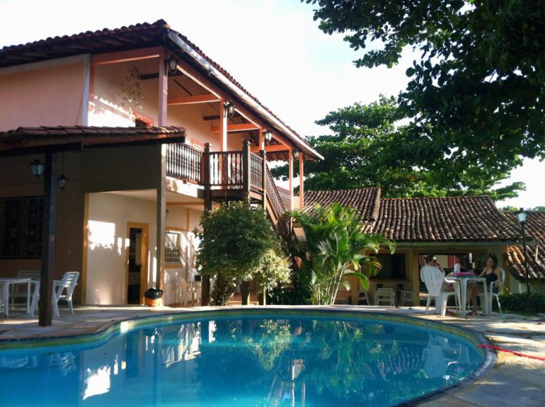 皮雷诺波利斯Pousada Pouso do Frade的房屋前有游泳池的房子