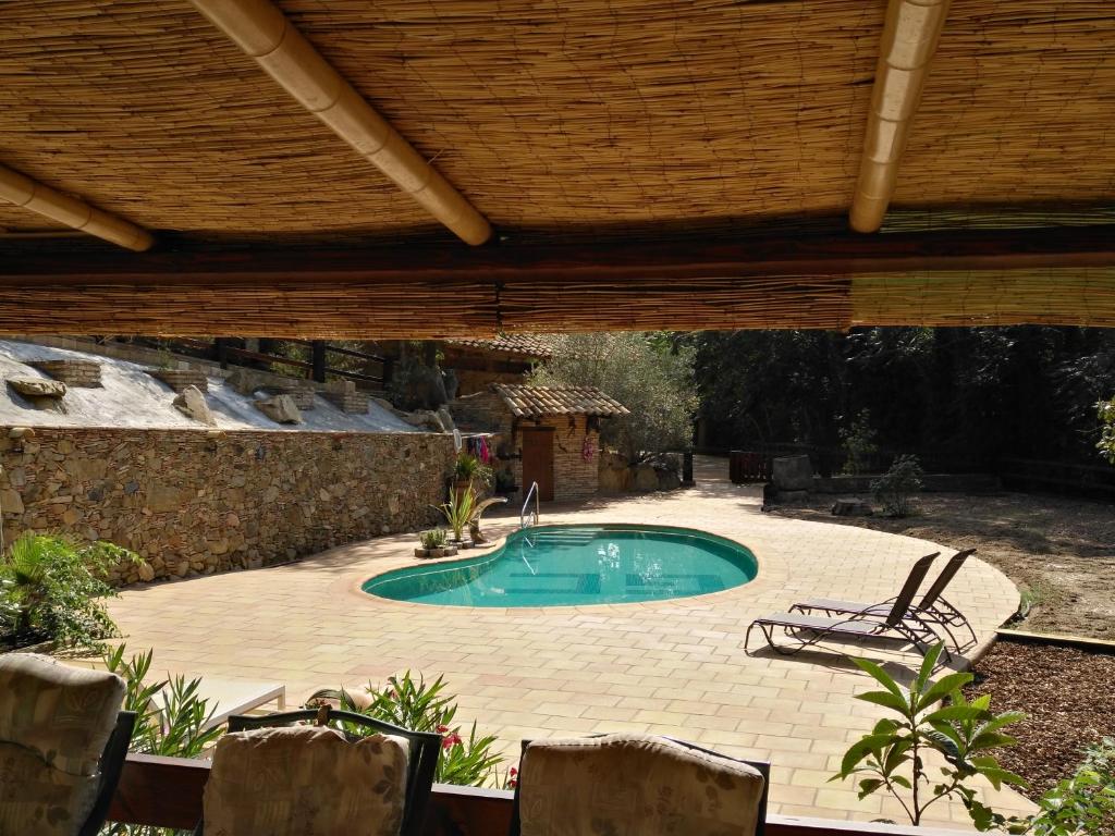 AiguavivaMas Font - Nature Bike的后院的游泳池,带有木屋顶