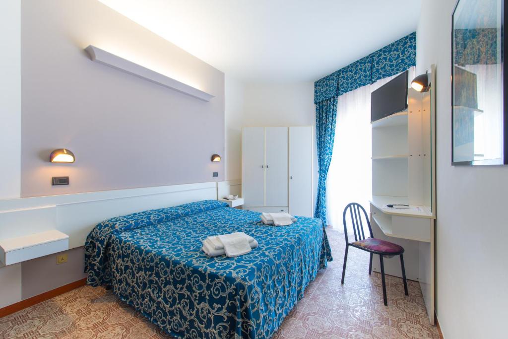 里米尼Hotel 2000的卧室配有床、椅子和窗户。