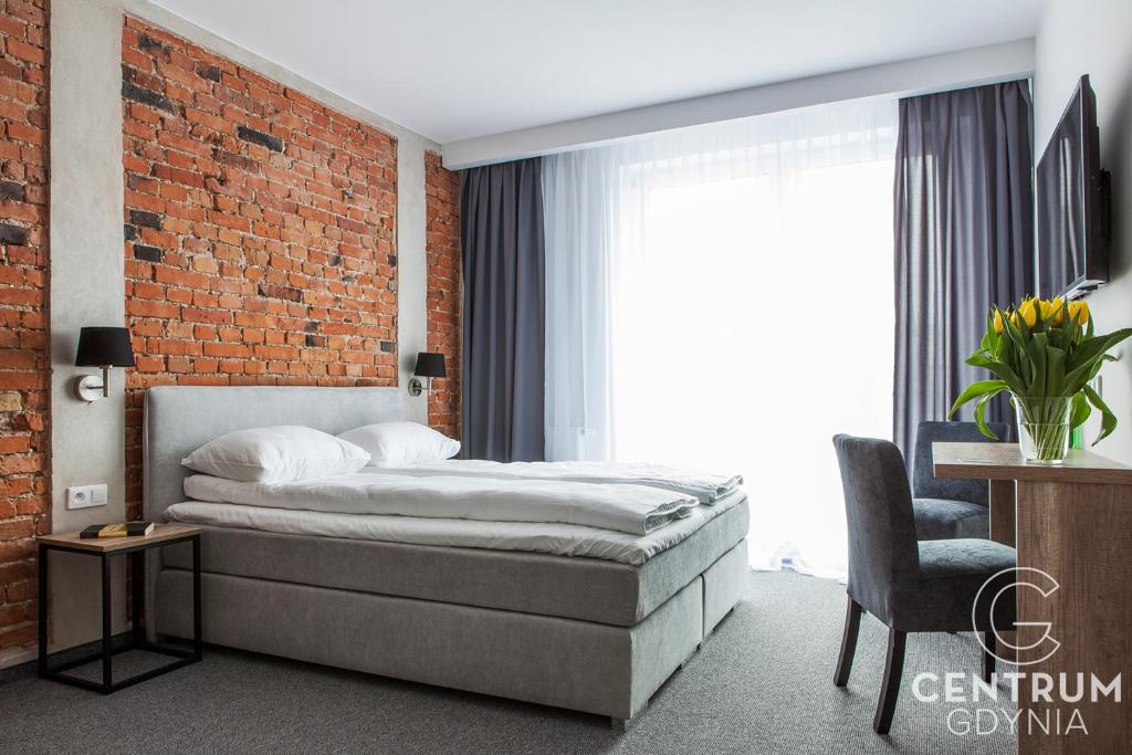 格丁尼亚Gdynia Centrum的一间卧室设有一张床和砖墙