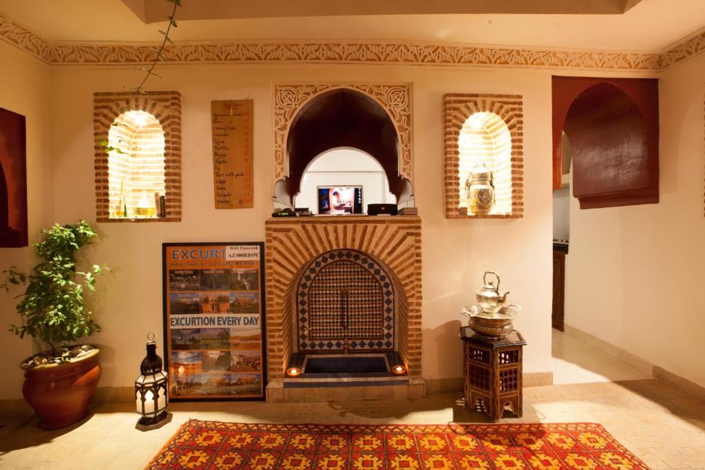 马拉喀什本萨利赫摩洛哥传统庭院住宅的客厅设有壁炉,铺着地毯