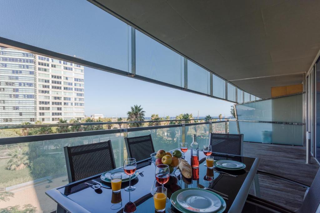 巴塞罗那Unique Rentals-Seafront Luxe Suites的阳台上的桌子上放着酒杯