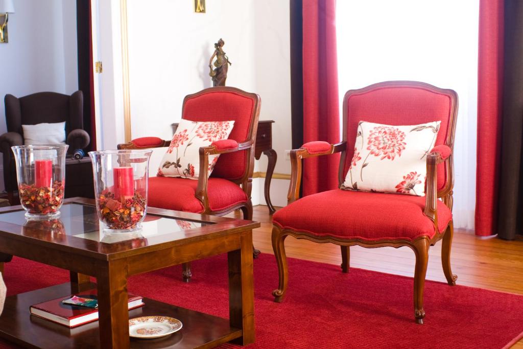 圣罗克杜皮库Casa do Comendador的客厅配有2把红色椅子和桌子