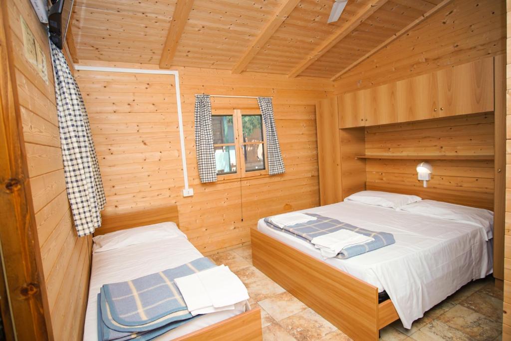 卡梅罗塔码头Villaggio La Siesta的小木屋内一间卧室,配有两张床