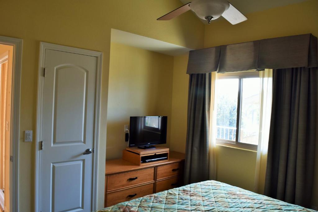 奥欣赛德Multi Resorts at Aquamarine Villas的一间卧室设有一张床、一台电视和一个窗口。
