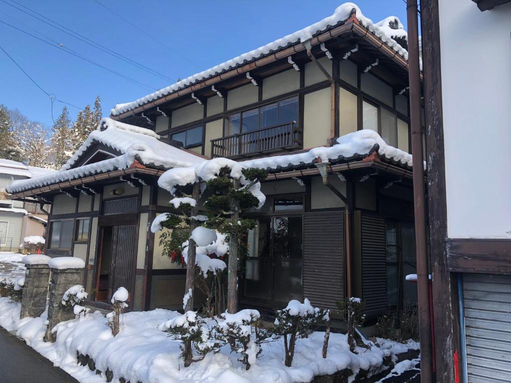 高山Guesthouse Takayama Hanzansha的雪覆盖着房子